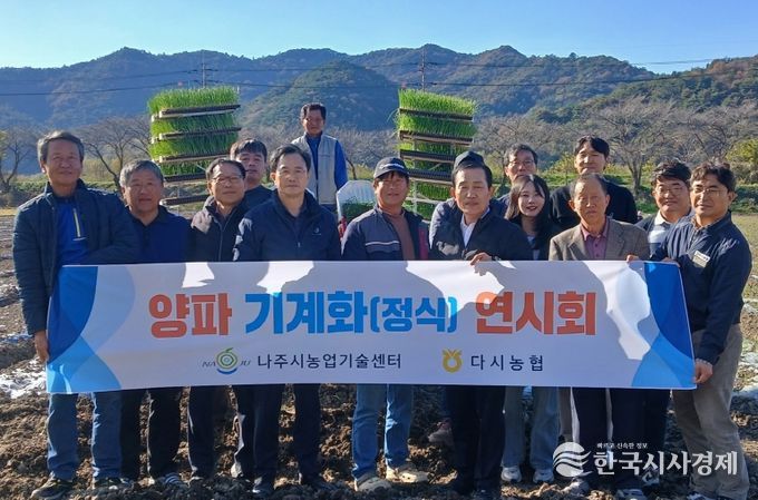 양파 기계 정식 연시회에 참가한 농업인들과 관계자들이 기념촬영을 하고 있다.