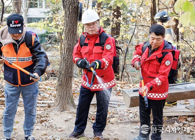 진교훈 서울 강서구청장(가운데)이 21일 오후 우장산 일대에서 열린 ‘유관기관 합동 산불진압훈련’에서 등짐펌프를 매고 산불진화대원과 함께 잔불진화작업을 하고 있다.