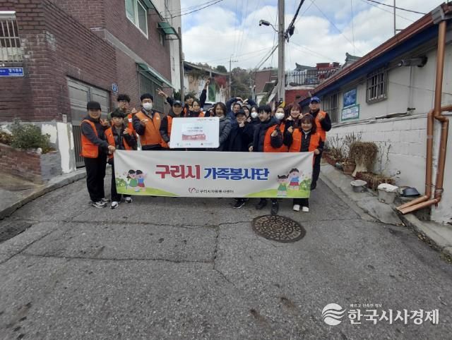 교문1동 이진수 동장과 구리시 가족봉사단 조은숙 단장이 후원받은 연탄 앞에서 포즈를 취하고 있다.