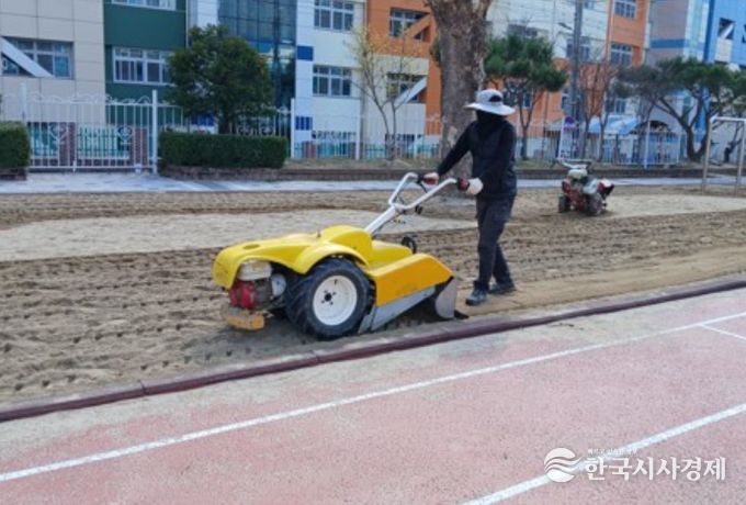 어린이 놀이시설 모래속 이물질 제거 및 탄성복원 작업 중