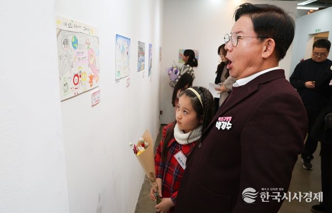 박강수 마포구청장이 수상 어린이와 함께 전시된 그림을 살펴보고 있다.