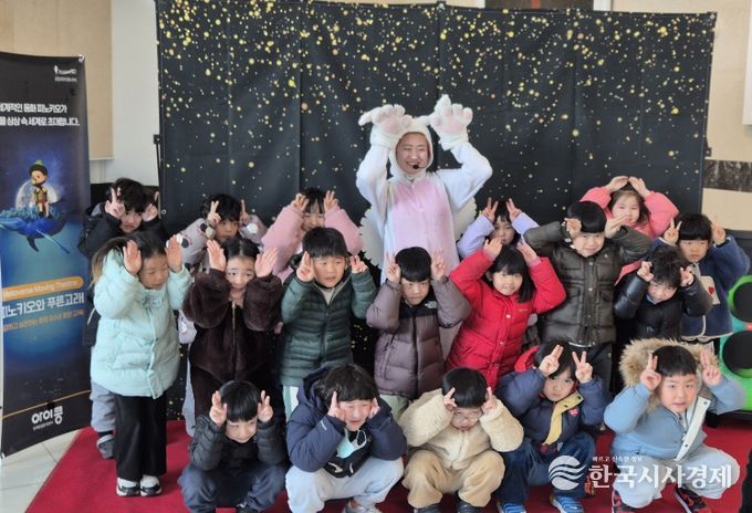 아이들이 공연 출연자와 함께 기념촬영을 하고 있다.