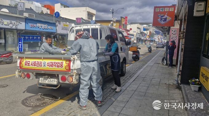 강진읍 일대 상가에 화분을 전달하고 있다.