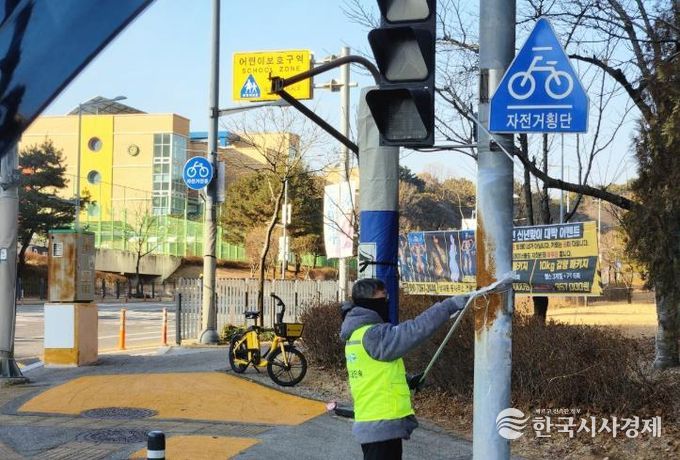 유성구청 직원이 어린이 보호구역 내의 불법광고물을 정비하고 있다