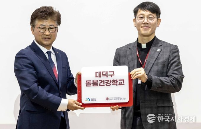 최충규 대덕구청장과 서용원 대덕구장애인종합복지관 관장이 12일 대덕구장애인종합복지관에서 열린 ‘돌봄건강학교 입학식’에서 현판을 들고 기념촬영을 하고 있다.