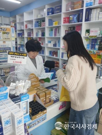 남구 치매안심약국 약사가 치매안심센터 직원의 설명을 듣고 있는 모습